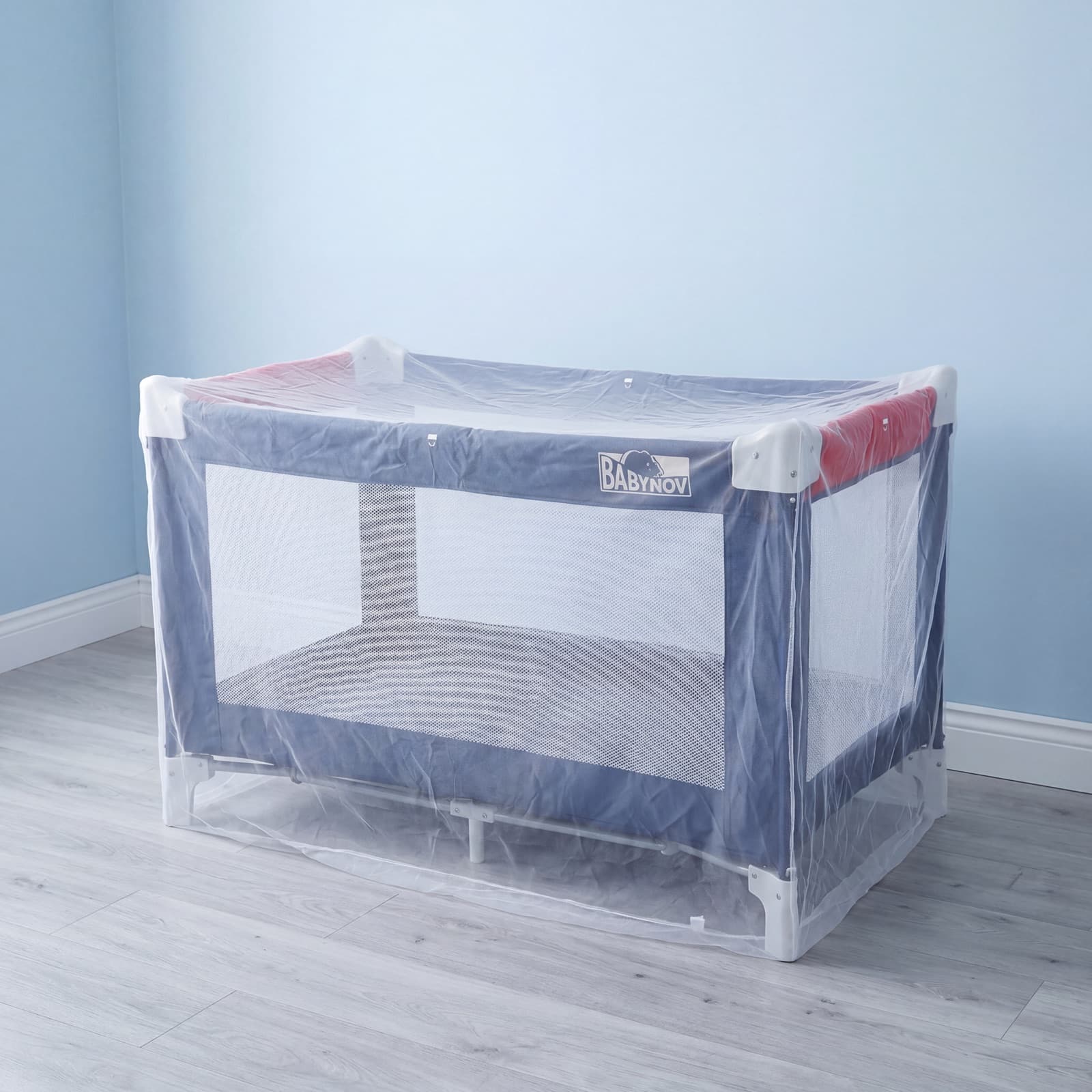 The Mosticare Bambino Dorme net covering a travel cot, ready for a baby away from home.
